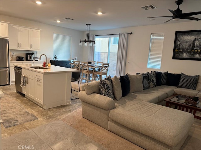 living room featuring recessed lighting, visible vents, and ceiling fan with notable chandelier