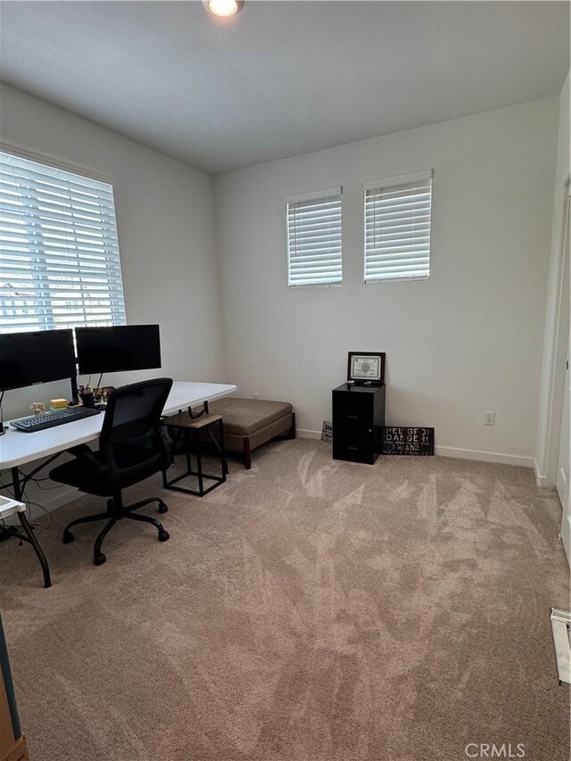 carpeted home office featuring baseboards