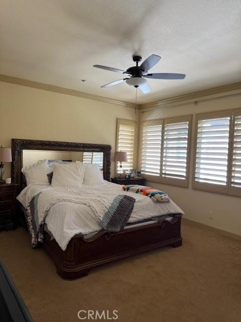 bedroom featuring crown molding, carpet flooring, and ceiling fan