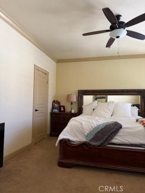 bedroom with ornamental molding, light carpet, and ceiling fan