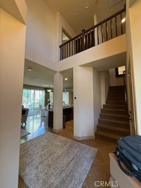 staircase featuring a high ceiling and tile patterned flooring