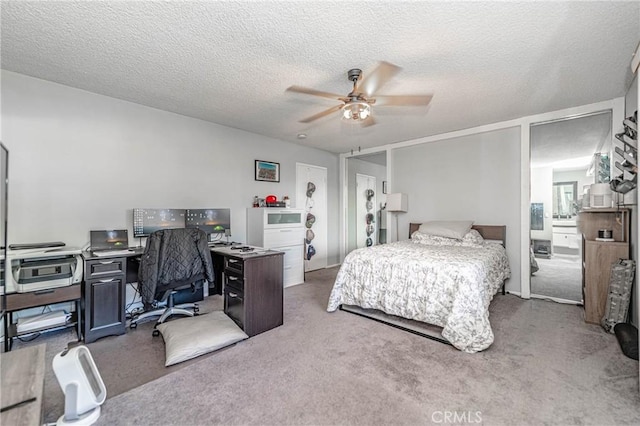 carpeted bedroom featuring a textured ceiling and ceiling fan