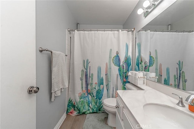 bathroom with toilet, vanity, curtained shower, and hardwood / wood-style floors