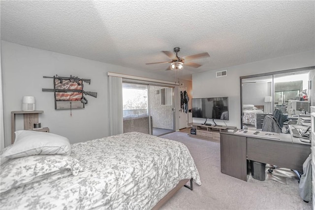 bedroom featuring ceiling fan, light colored carpet, access to exterior, and a textured ceiling