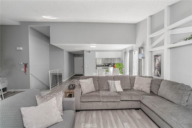 living room with a textured ceiling and hardwood / wood-style flooring