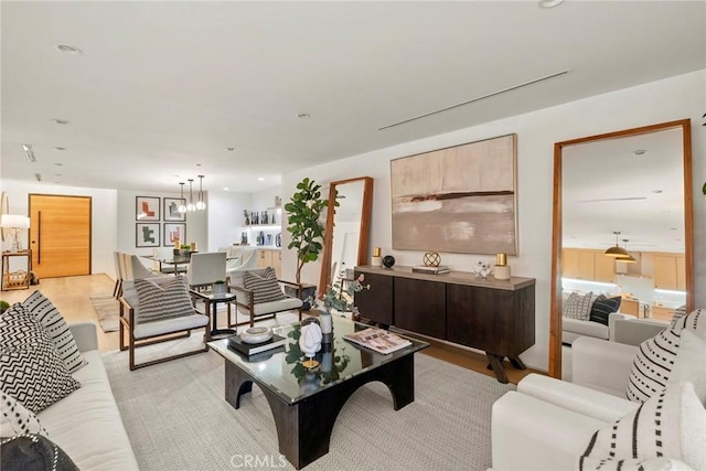 living room with a chandelier, recessed lighting, and light wood-style flooring