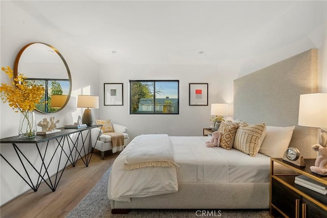 bedroom with multiple windows and wood finished floors