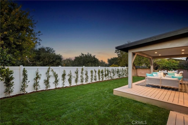 yard at dusk with an outdoor living space and a wooden deck