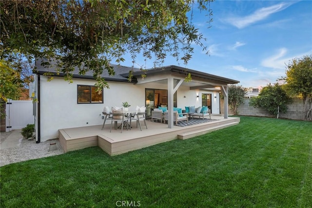 back of house with a yard, outdoor lounge area, a fenced backyard, and stucco siding