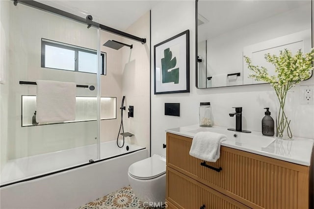 full bathroom featuring toilet, vanity, and shower / bath combination with glass door