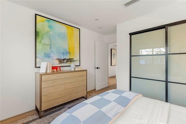 bedroom with wood finished floors and visible vents