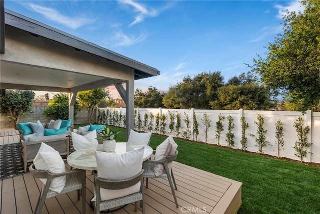 deck featuring outdoor dining area, outdoor lounge area, a fenced backyard, and a lawn