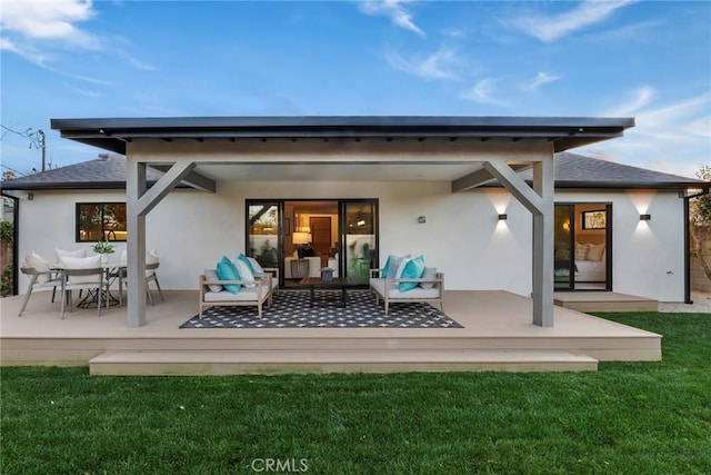 rear view of house featuring a wooden deck, a yard, and outdoor lounge area