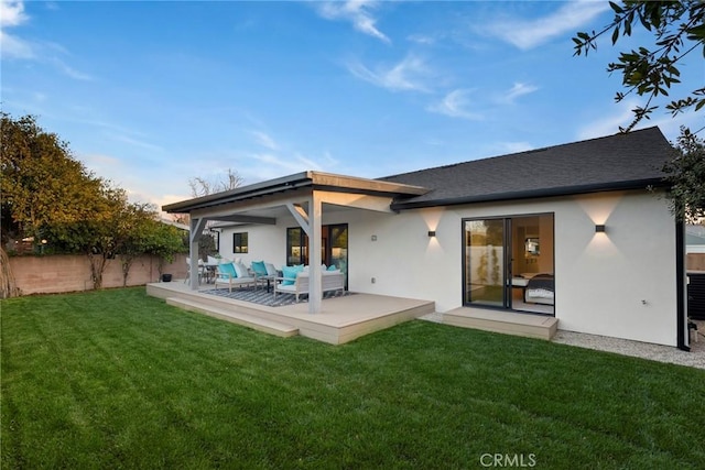 back of property with fence, an outdoor living space, a yard, stucco siding, and a patio area