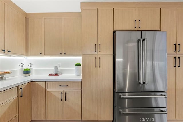 kitchen featuring high end refrigerator and light brown cabinets