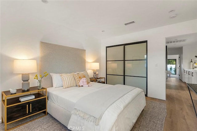 bedroom with wood finished floors and visible vents