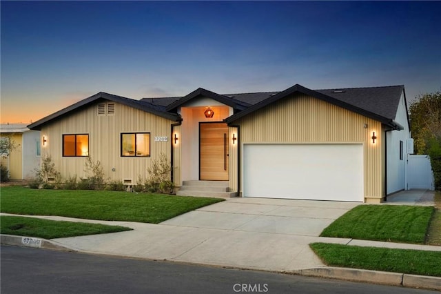 view of front of house featuring a garage and a lawn