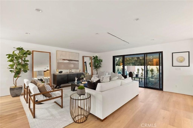 living area with light wood-style flooring and recessed lighting