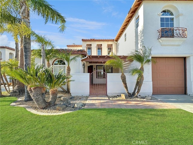 mediterranean / spanish house featuring a garage and a front yard