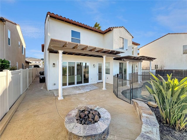 rear view of house featuring a pergola, a fire pit, and a patio