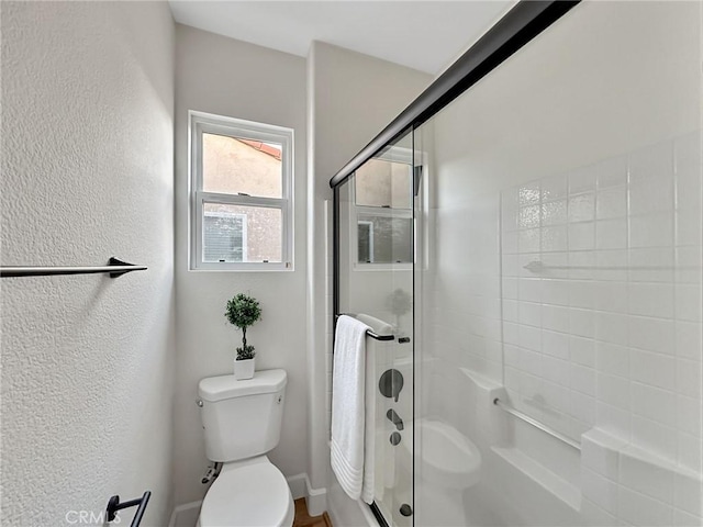 bathroom featuring an enclosed shower and toilet