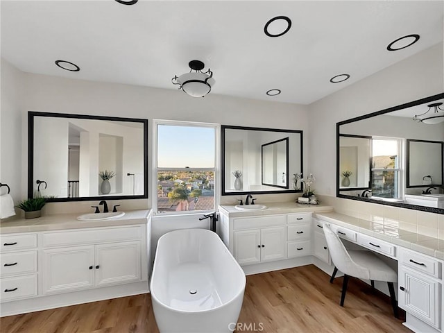 bathroom with vanity, a washtub, and hardwood / wood-style flooring