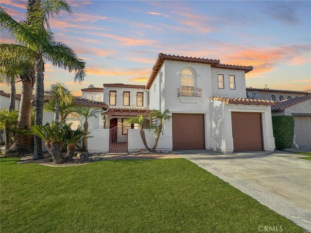 mediterranean / spanish-style home with a garage and a lawn