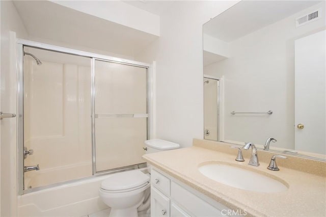 full bathroom featuring vanity, shower / bath combination with glass door, and toilet