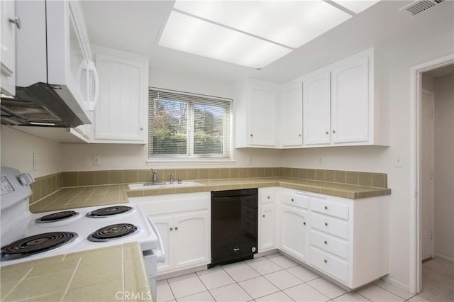 kitchen featuring tile countertops, white cabinetry, sink, light tile patterned floors, and white appliances