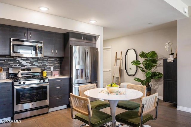 kitchen featuring backsplash, stainless steel appliances, and wood-type flooring