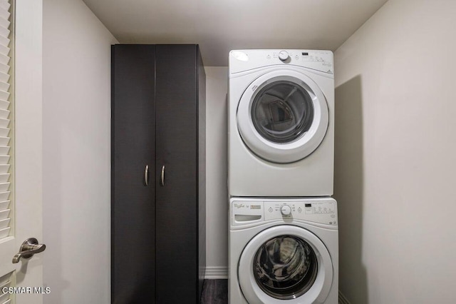 washroom with stacked washing maching and dryer