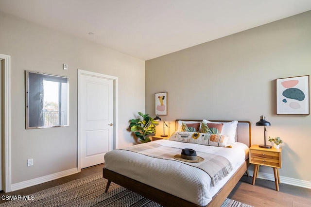 bedroom with dark hardwood / wood-style flooring