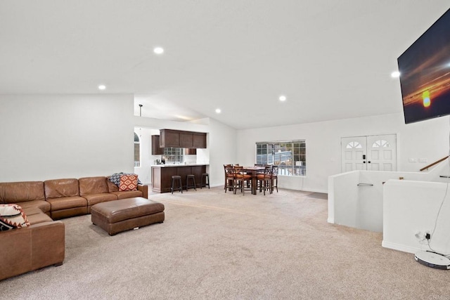 carpeted living room featuring lofted ceiling and french doors