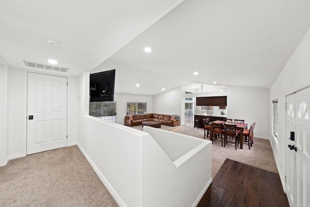 living room with vaulted ceiling and light colored carpet