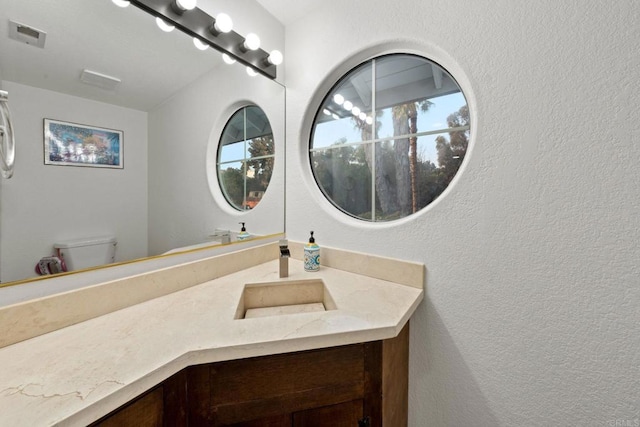 bathroom featuring vanity and toilet