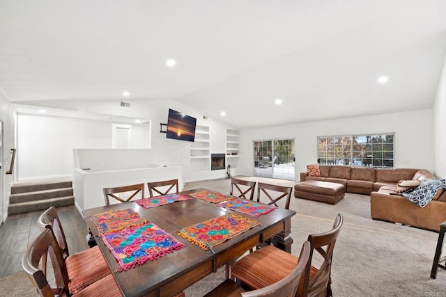 dining room with built in shelves and lofted ceiling