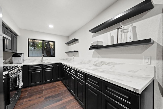 kitchen featuring extractor fan, light stone countertops, sink, and stainless steel gas stove