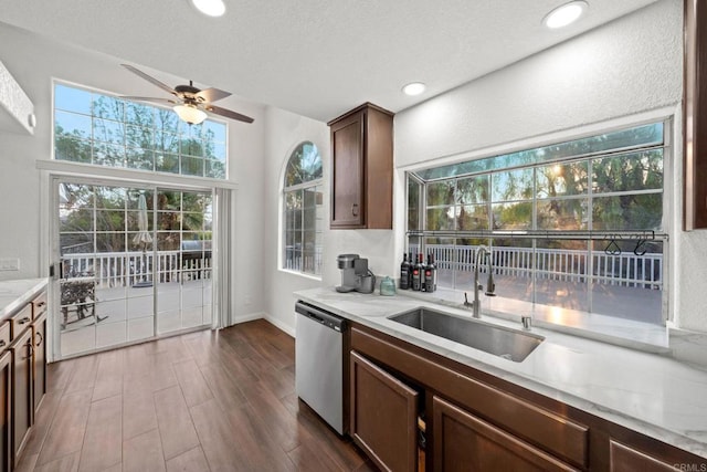 kitchen with sink, dark brown cabinets, plenty of natural light, and stainless steel dishwasher