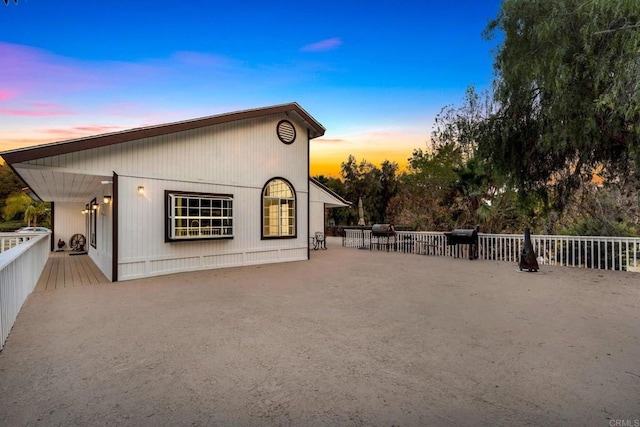 property exterior at dusk featuring a patio area