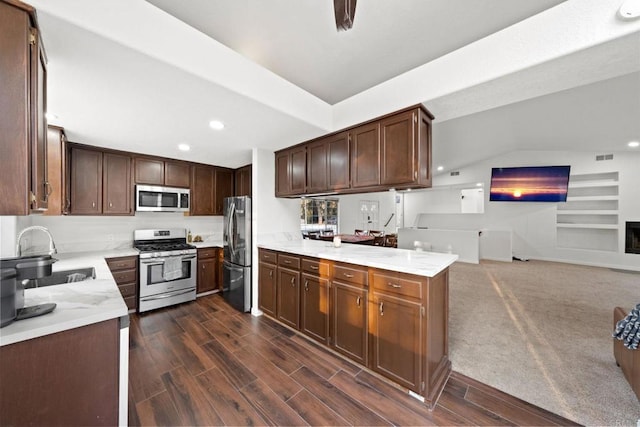 kitchen with sink, dark brown cabinets, kitchen peninsula, and appliances with stainless steel finishes