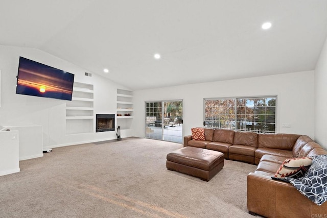 living room featuring built in shelves, light colored carpet, and vaulted ceiling