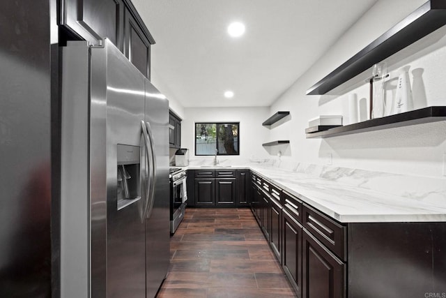 kitchen featuring light stone counters, sink, and appliances with stainless steel finishes