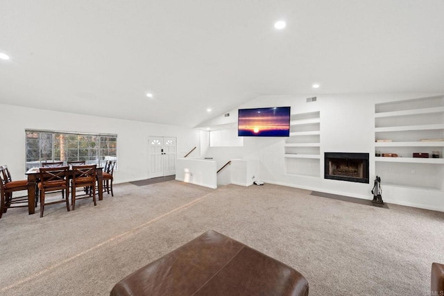 living room with lofted ceiling, carpet flooring, and built in features