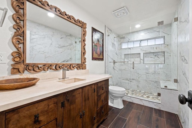 bathroom featuring an enclosed shower, vanity, and toilet