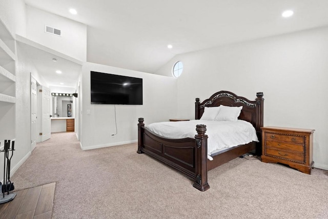 bedroom featuring ensuite bath, light colored carpet, and a towering ceiling