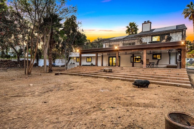 view of front of house with a patio area and solar panels