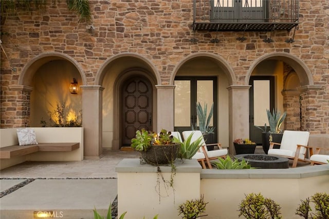 entrance to property featuring a balcony and a patio area