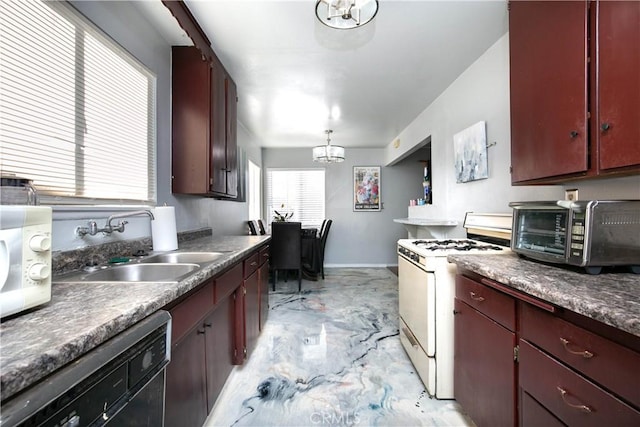 kitchen with sink, white appliances, a notable chandelier, and hanging light fixtures