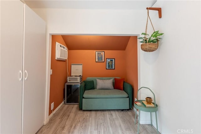 living area with light wood-type flooring and a wall mounted AC