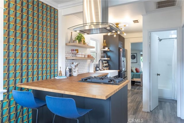 kitchen featuring crown molding, island range hood, sink, dark hardwood / wood-style floors, and black gas cooktop